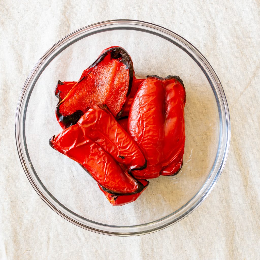 Roasted red peppers in a glass bowl.