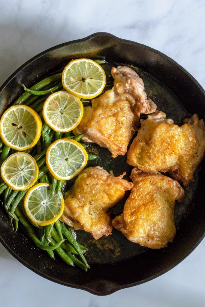 Fresh Green Beans with Chicken Thighs and Lemon Pepper Seasoning in a cast iron skillet.