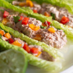 Fiesta tuna salad in romaine lettuce boats on a white plate.